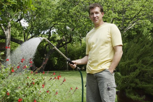 Local gardener trimming hedges and tidying borders in Turnhamgreen